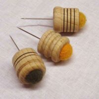 Puntaspilli in feltro e base in legno con spillone per tombolo